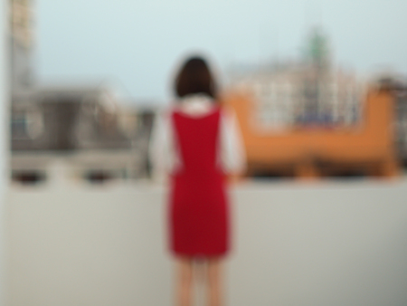 Blurred abstract background of standing Asian woman in red dress, business concept.の写真素材