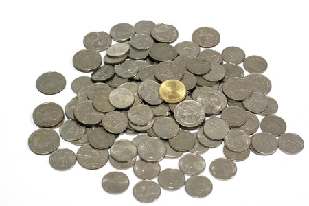 A pile of silver coins on top with a golden coin with white background, business concept.