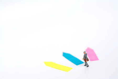Three direction arrow choices, left, right or move forward, miniature model figure of businessman are taking decisions for the future, choice way.の写真素材