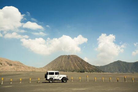 White off-road 4x4 adventure vehicle parking at sideway with the white and yellow milestone poles,...