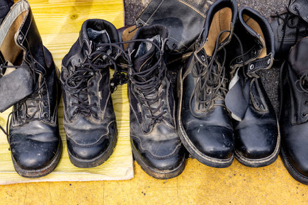 Old dirty black boots on the floor in a flea market.の写真素材