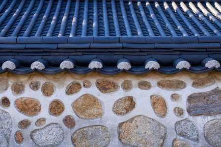 Roof tile pattern of korea with stone wall background.の写真素材