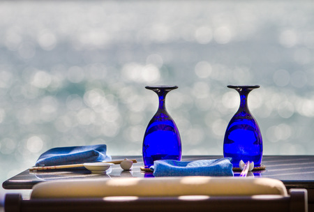 Blue glasses and cutlery on sea backgroundの写真素材