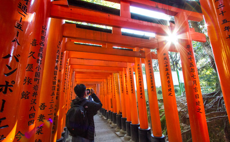 E-KYOTO, JAPAN - NOVEMBER 2015 :  Tourists admiring the structure of Fushimi Inari Taisha Shrine.のeditorial素材