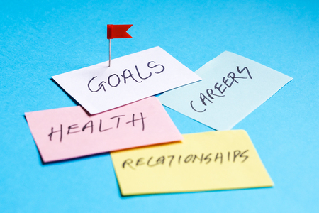Goals in careers, health and relationships written on colored papers