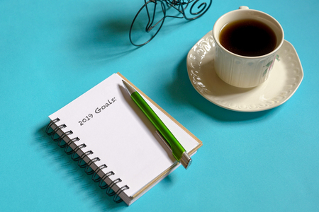 Top view 2019 goals list with memo pad, cup of coffee and pen on pastel blue backgroundの写真素材