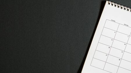 Calendar page on black background. Top view. Appointments or schedule concept. With copy spaceの写真素材