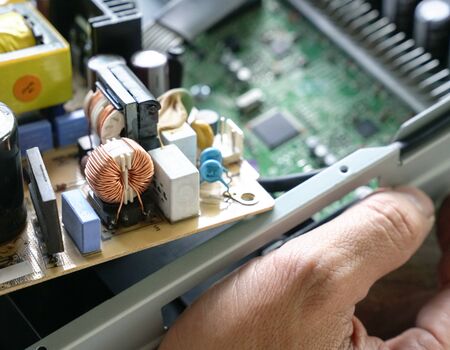 Hands holding PCB board while fixing  faulty sound equipment.の写真素材