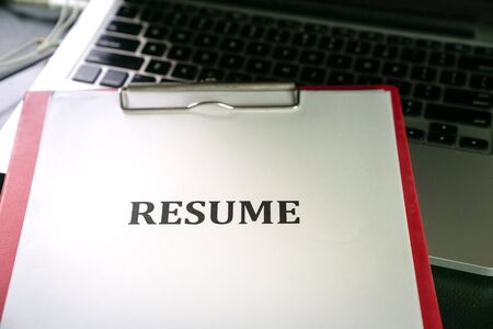 Closeup of resume on top of computer laptop on tableの写真素材