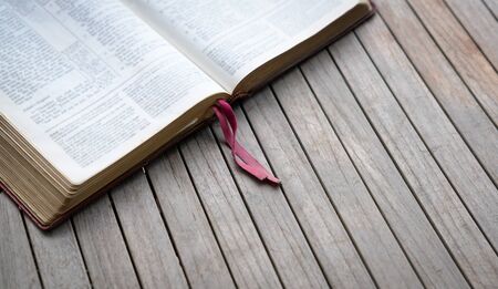Open bible on wooden table. Soft blur effect with focus on book mark. Copy space.の写真素材
