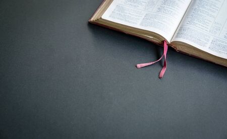 Top view of open Holy Bible  on the black color table. Space fpr text.
