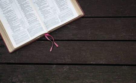Top view of open Holy Bible  on the corner of dark wood backgroundの写真素材