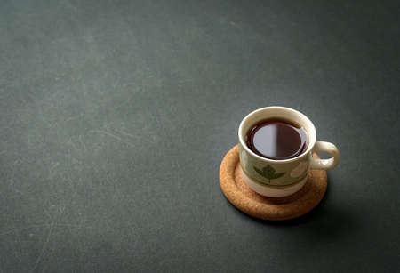 Coffee cup on rustic black tabletop. Top view with copy space for text.の写真素材