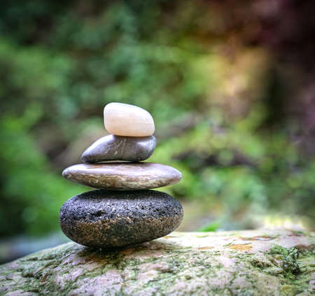 Pebble tower with green nature and water background. Zen, spa or wellness concept.の写真素材