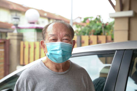 Elderly man with medical face mask at home. Stay at home to reduce risk of Covid-19.