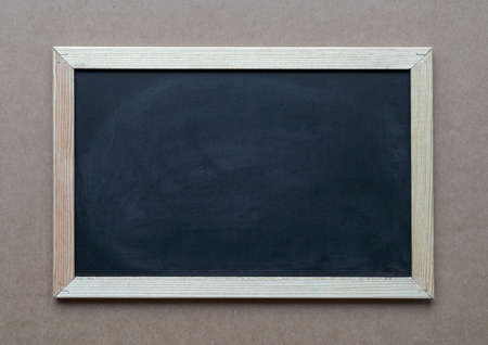 Blank blackboard on brown carrdboard background. Copy space.の写真素材