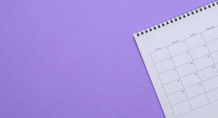 Calendar on purple background. Top view. Copy space.