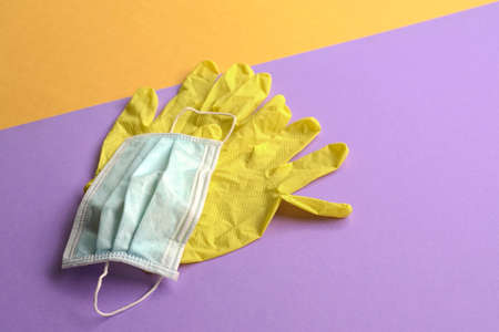 Hand gloves and medical face mask on purple  and yellow background. Top view.の写真素材