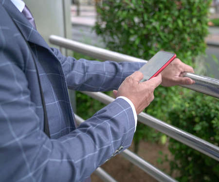 Close up shot of businessman surfing or reading his cellphone