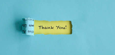 Torn blue paper with Thank You text on yellow background. Appreciation concept.