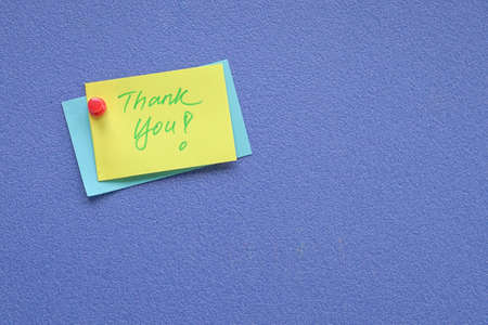 Thank you note pin on blue board. Copy space.の写真素材