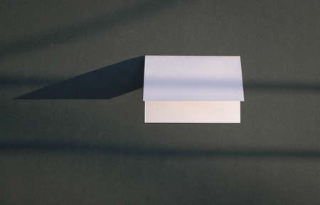 Empty white card with shadows on black background. Copy space.の写真素材