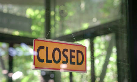Closed signboard hanging on glass door of a restaurant. Copy space.の写真素材