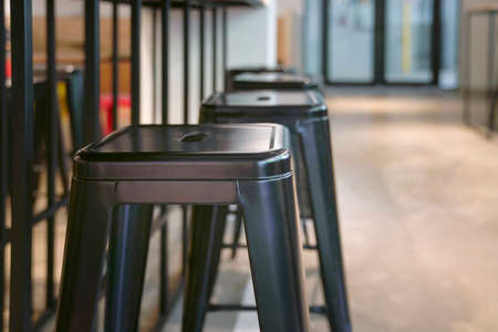Close up of black metal stools in an empty restaurant.の写真素材