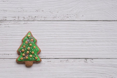 Gingerbread cookie of green Christmas tree on white wood background. Copy space.の写真素材