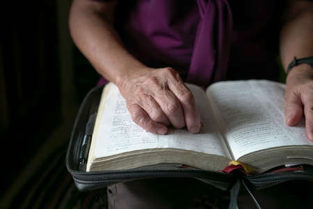 Senior woman reading, close up view on her right hand.の写真素材