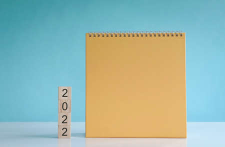 2022 for a new start, text on wood cubes next to blank yellow background calendarの写真素材