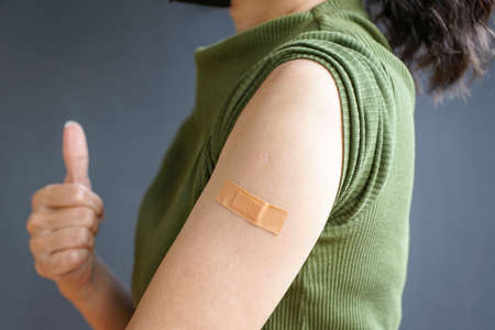 Close up view of woman arm with bandage, getting vaccinated immunity. Inoculation, vaccination,...