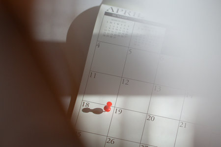 Calendar with red pushpin on April 18th. Tax day deadline concept.の写真素材