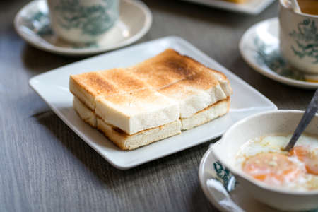 Oriental traditional Hainanese breakfast set with toast bread, half boiled eggs and coffee.の写真素材