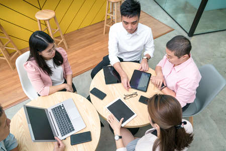 Business people with digital tablets, smartphone and laptop on table. Close up view.
