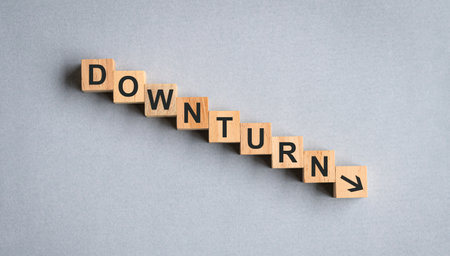 Downturn, word on wood block. Concept for recession or economy downturn.