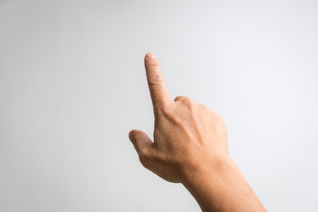 Male hand with index finger pointing to something. White background.の写真素材