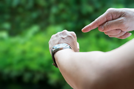 Man pointing his finger to his watch. It's time or hurry concept.