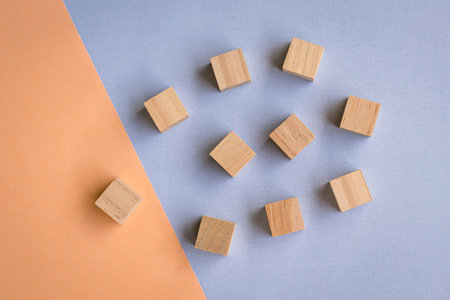 Wooden blocks on blue and oange background. Leadership, human resources, team or hiring concept.