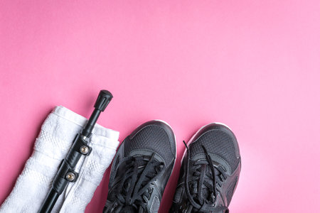 Towel, hiking stick and sport shoes on pink background. Hiking concept.の写真素材