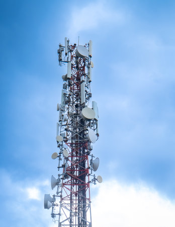 Telecommunication tower with blue and white clouds sky. Copy space.