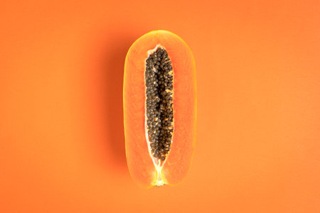 Ripe papaya fruit on bright orange background. Copy space.の写真素材
