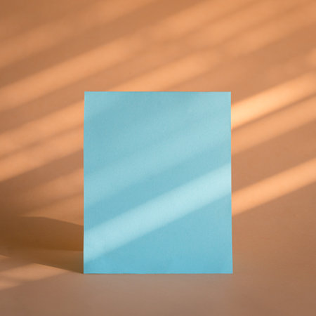 Blank blue paper sheet card with beige background and sunlight and shadows. Business brand template.の写真素材