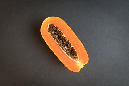 Ripe papaya fruit on black background. Copy space.