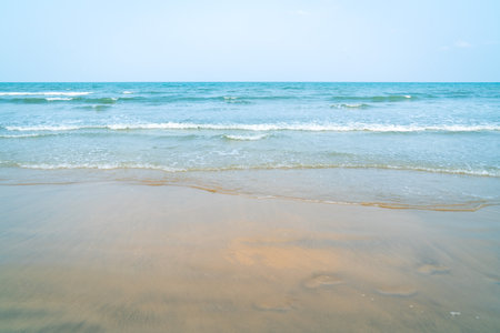 Tropical beach and seascape. Sunset hour, orange hue reflection on soft sand. Tranquil scene.