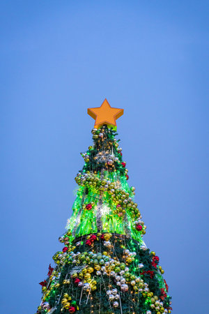 Beautifully decorated Christmas tree lighted up, with evening blue sky background. Copy space.の写真素材