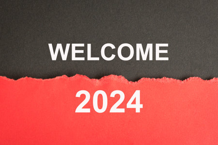 Welcome 2024, word on black and red torn paper. New year concept.の写真素材