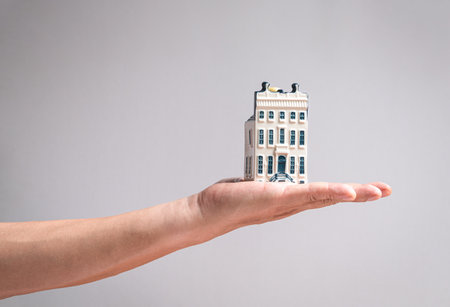 Hand holding a model mansion house. Real estate or property concept.の写真素材