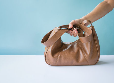 Woman holding a brown leather bag. Copy space.の写真素材