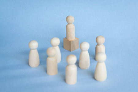 People toy blocks with one standing on a podium. Illustrate leadership concept.の写真素材